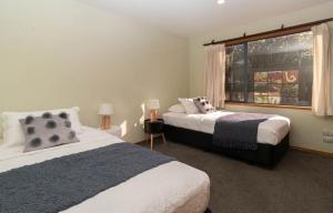 1 dormitorio con 2 camas y ventana en Beachfront Bliss On Wanaka Terrace Support Local, en New Plymouth