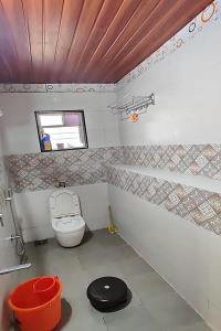 a small bathroom with a toilet and a window at Sunshine Resort in Pune