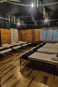 um quarto com fileiras de colchões e lustres em Sunshine Resort em Pune