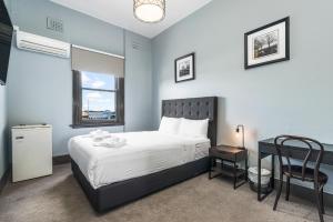 - une chambre avec un lit, une table et une chaise dans l'établissement The Great Western Hotel, à Orange
