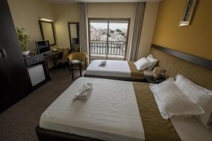 En eller flere senge i et værelse på Holy Family Hotel