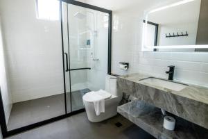 ein Bad mit einer Dusche, einem WC und einem Waschbecken in der Unterkunft 929 Villa in Ranau