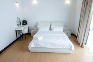 929 Villa في راناو: غرفة نوم بيضاء مع سرير أبيض ومكتب