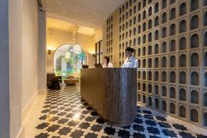 two people sitting at a reception desk in a lobby at Cinco Quintas Hotel Boutique in Cartagena de Indias