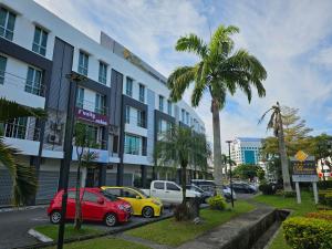 eine Straße mit Autos, die vor einem Gebäude geparkt sind in der Unterkunft DeHome Boutique Hotel in Kuching