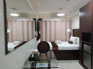 a hotel room with a bed and a mirror at Studio unit at The Breeze Residence in Manila