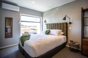 a bedroom with a large bed and a window at THE Residence Apartment 8 50 Sky in New Plymouth