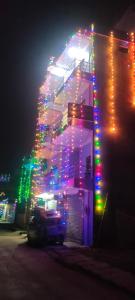 a lit up building with christmas lights on it at Kavre Guest House in Lumbini