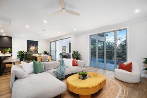 a living room with two couches and a table at Cicada Close Hideaway in Buderim