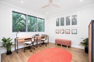 an office with a desk and two chairs and a fan at Cicada Close Hideaway in Buderim