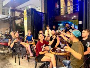 a group of people sitting at tables in a restaurant at Saigon Chill Hostel in Ho Chi Minh City