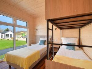 two bunk beds in a room with a window at Cozy holiday homes for 4 people, azy in Łazy