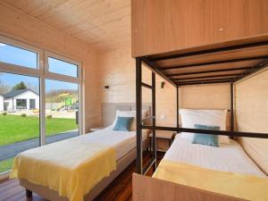 two bunk beds in a room with a window at Cozy holiday homes for 5 people, azy in Łazy