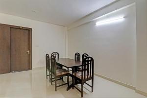 uma sala de jantar com uma mesa e cadeiras e uma porta em The Bunglo (Villa) em Allahabad
