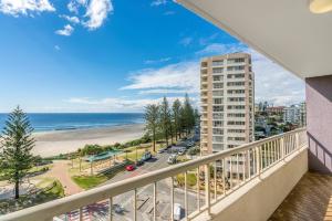 a balcony with a view of a beach and a building at Eden Tower Apartments in Gold Coast