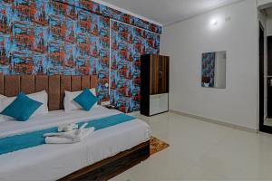 um quarto com uma cama grande e almofadas azuis em The Bunglo (Villa) em Allahabad