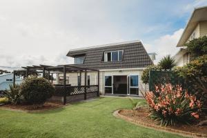 a home with a black roof and a yard at Blue Haven On Belt Waterfront in New Plymouth