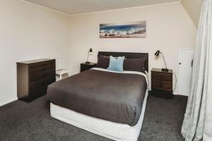 a bedroom with a large bed and two night stands at Blue Haven On Belt Waterfront in New Plymouth