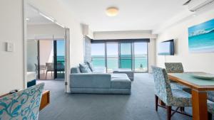 a living room with a couch and a table and chairs at Sea Side 508 in Mandurah