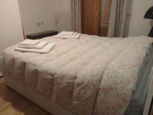Una cama con tres toallas encima. en Breakfast in garden mountain view, en Calalzo