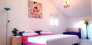 1 dormitorio con 1 cama y una pintura en la pared en Apartments Slavica Trogir, en Trogir