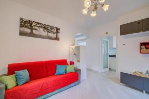 ein rotes Sofa im Wohnzimmer in der Unterkunft Casa dei Nonni - Happy Rentals in Arco