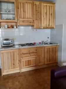 - une cuisine avec des placards en bois et un évier dans l'établissement Breakfast around the mountains, à Nebbiu