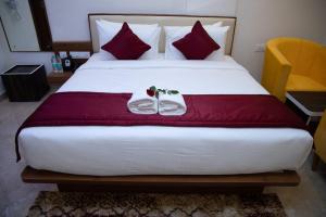 a bedroom with a large bed with red pillows at Hotel Grand Villa in Yelahanka