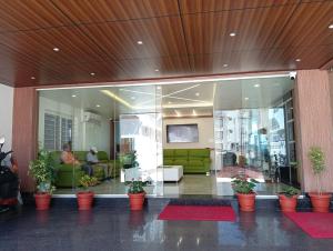 a lobby with a green couch in a building at Hotel Grand Villa in Yelahanka