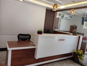 a reception desk with a bench and a table at Hotel Grand Villa in Yelahanka