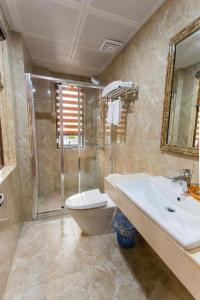 y baño con aseo, lavabo y ducha. en Aroma Cat Ba Sea View Hotel, en Cat Ba