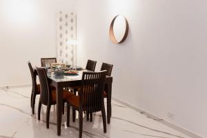 a dining room with a table with chairs and a mirror at Luho C 7 in Bangalore