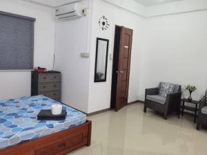 a bedroom with a bed and a chair in it at Casa Kristar in Mamburao