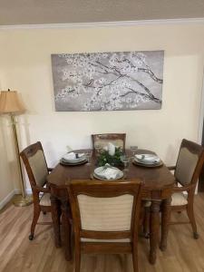 una mesa de comedor con 4 sillas y una pintura en Bright cheery spa restful home., en Parsons