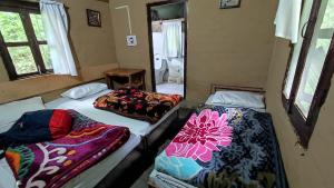 a room with three beds in it with a bathroom at Hail Himalayas in Chail