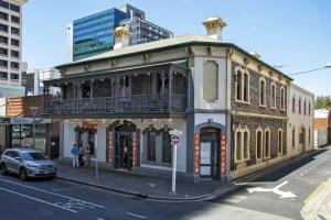 an old building on the corner of a street at Tequila Sunrise Hostel Adelaide in Adelaide