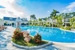 una imagen de una piscina en un complejo en Vườn Vua Resort & Spa -by Bay Luxury, en Ðồng Phú