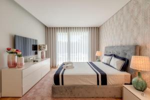 ein Schlafzimmer mit einem großen Bett und einem TV in der Unterkunft Luxurious 5 bedrooms and with pool in Fernão Ferro