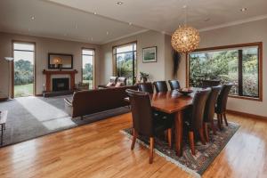 a dining room with a table and chairs and a couch at Serenity Lodge Getaway in Egmont Village