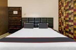 a bedroom with a large bed with two chairs at Manasi Residency in Bangalore