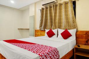a bedroom with a large bed with red pillows at OYO Hotel Paradise in Pune
