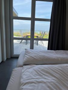 Ένα ή περισσότερα κρεβάτια σε δωμάτιο στο Enkhuizer Strand Chalet IJsselmeerstrand Erste Reihe mit Zaun Hausnr 204
