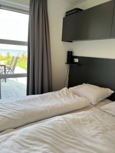 Ένα ή περισσότερα κρεβάτια σε δωμάτιο στο Enkhuizer Strand Chalet IJsselmeerstrand Erste Reihe mit Zaun Hausnr 204 +12 φωτογραφίες