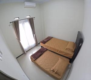 a small room with two beds and a window at BMR B3 Homestay Jogja in Ngingas +13 photos