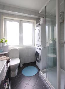 ein Bad mit einer Dusche und einer Waschmaschine in der Unterkunft Førde sentrum - Lindbøen Gjesterom in Førde