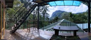 a balcony with a bench and a view of a mountain at Madushanka Resort in Ella