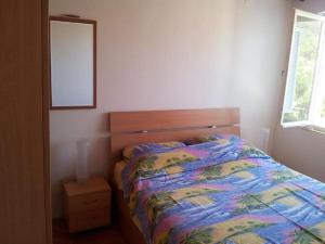 sypialnia z łóżkiem z kolorową kołdrą w obiekcie Apartment Mila - 80m to the beach w mieście Brna