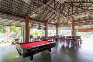 a pool table in a room with tables and chairs at Namsai Resort Kanchanaburi in Kanchanaburi