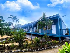 ein blaues Gebäude mit Palmen davor in der Unterkunft Coconut Palms Resort & Diamond Casino in Port Vila