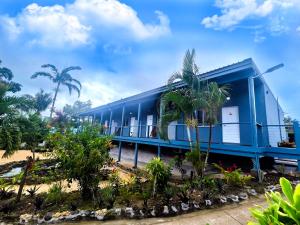 een blauw gebouw met palmbomen ervoor bij Coconut Palms Resort & Diamond Casino in Port Vila